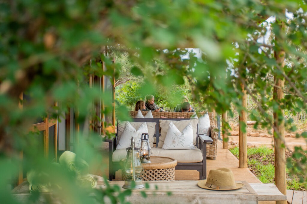 Family and friends gathered on the veranda at Baobab Hill House at golden hour