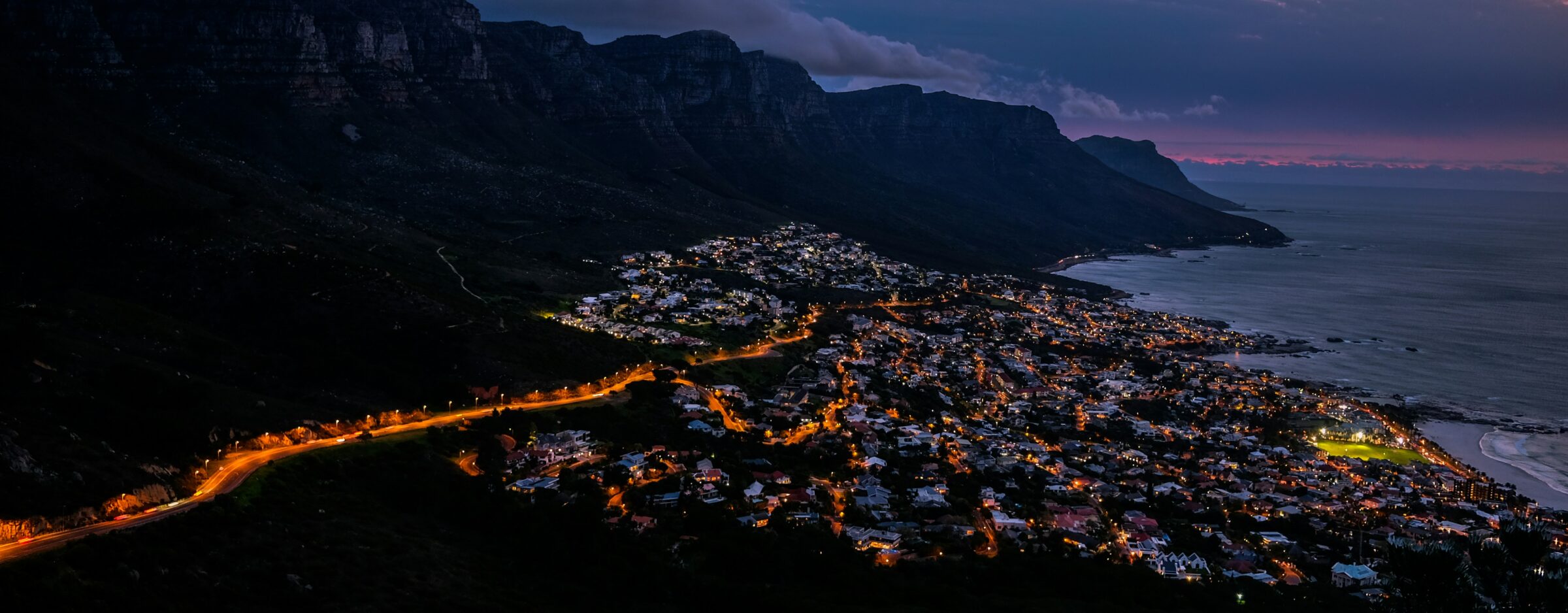 Camps Bay beach and the Twelve Apostles mountains under a clear blue summer sky