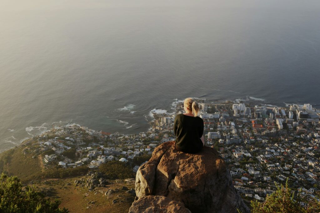 Hikers enjoying the view from Lion’s Head in golden light with the city below